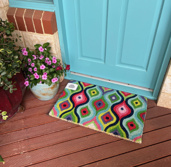 Colourful geometric-patterned doormat in green with hot pink by Anna Chandler Design