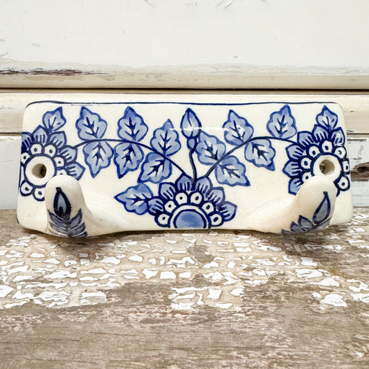 Decorative ceramic hook with blue floral patterns on white glossy glaze
