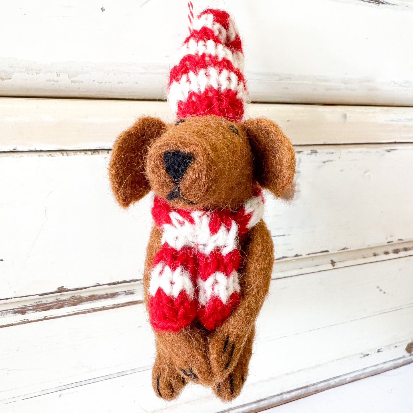 Felted dog decoration wearing a red and white striped hat and scarf. Christmas Decorations - Dog Daniel