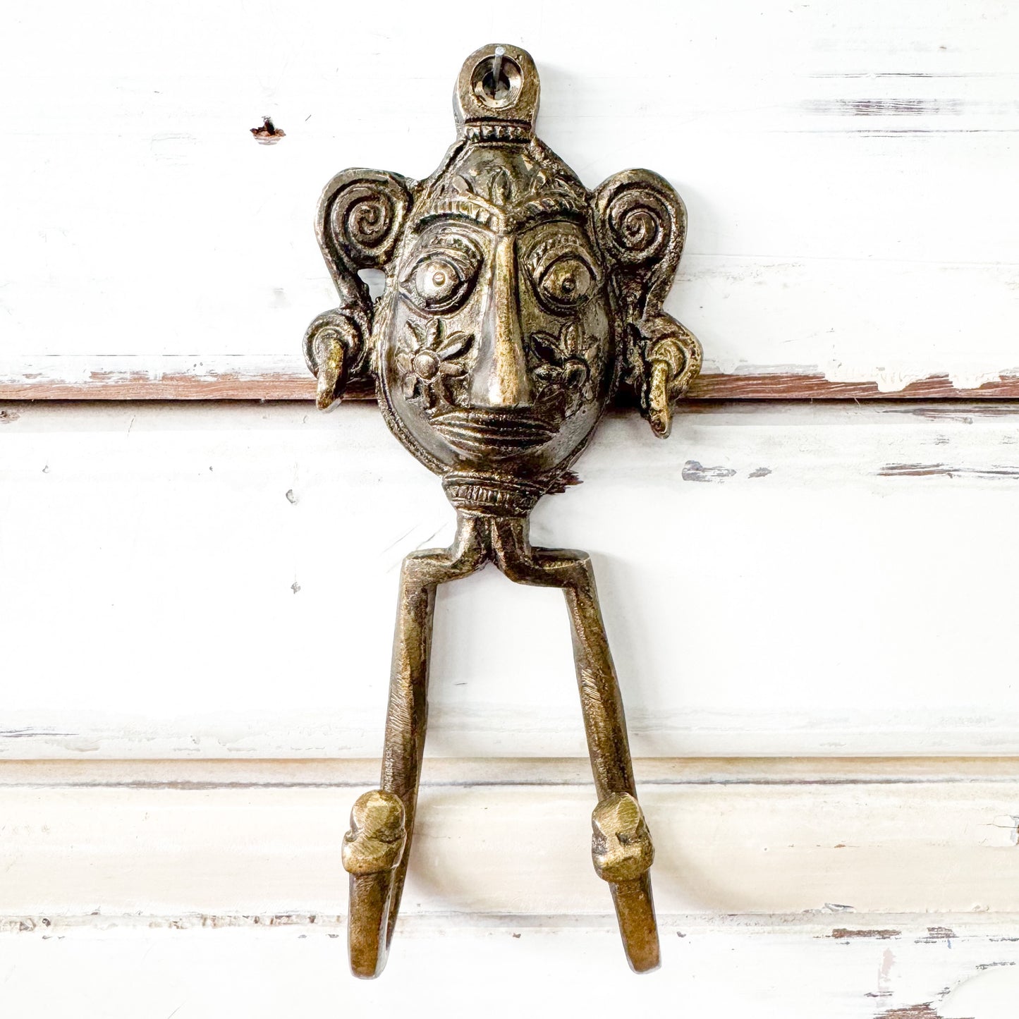 Bronze mask-like face with a double hook.