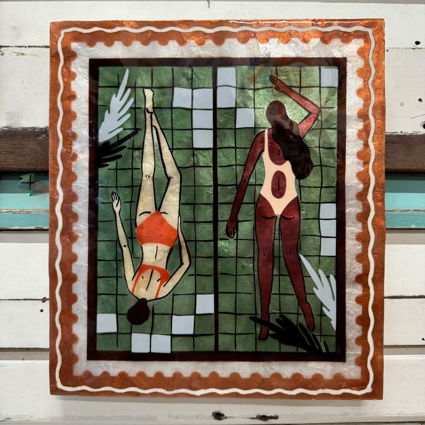 Jones & Co - Resort Laps Green - Artistic depiction of two people in swimsuits against a tiled wall with a decorative frame.