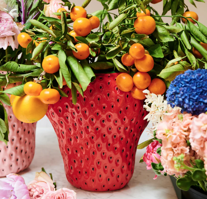 Kip&Co Strawberry Vase - Red strawberry-shaped vase with black pips & filled with green leaves and orange fruits.