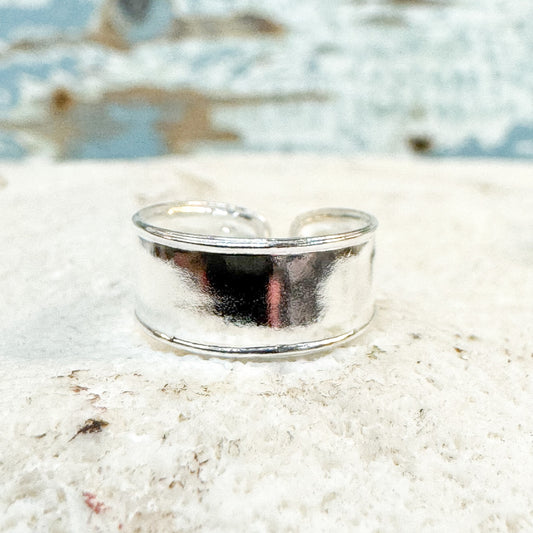 The Brightside Store - Classic Toe Ring Silver ring on a sandy surface with a blurred natural background