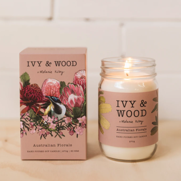 Australian Florals Candle by Ivy & Wood in a glass jar with a floral design label, next to its packaging box also with floral design.