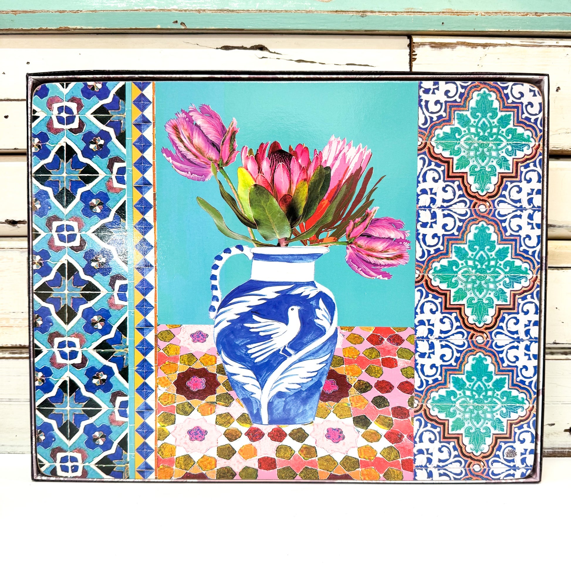 Decorative mat with a blue and white vase holding pink flowers, surrounded by colorful geometric patterns 
Anna Chandler Design - Placemat Set 4 - Vases on Turquoise