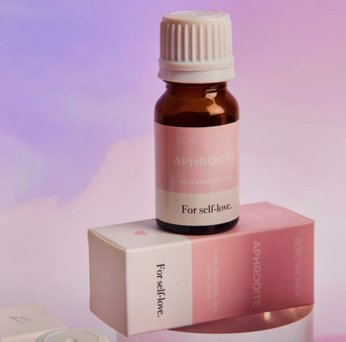 Aphrodite essential oil bottle and box on a soft pink background
