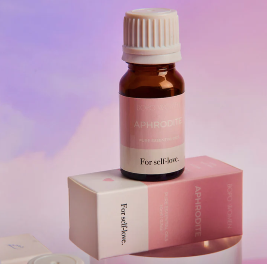 Aphrodite essential oil bottle and box on a soft pink background