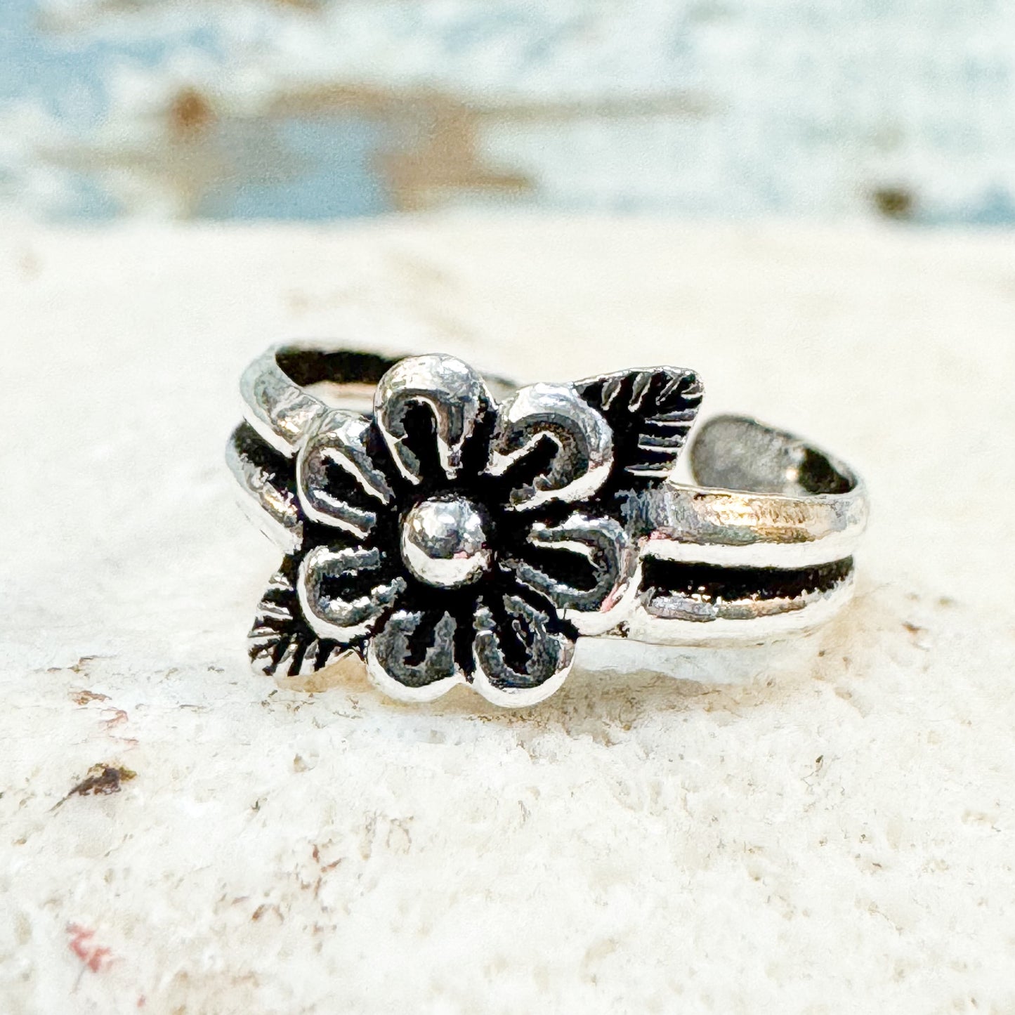 Available at The Brightside Store - Flower Toe Ring Silver floral ring on a textured white surface