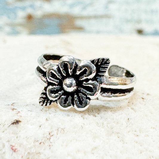 Available at The Brightside Store - Flower Toe Ring Silver floral ring on a textured white surface