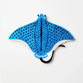 Blue stingray-shaped bath mat with black spots on a white background