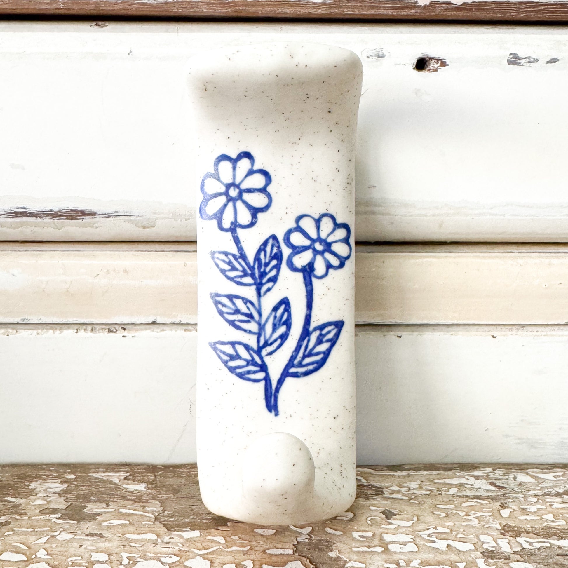 White ceramic adhesive hook with blue floral design 