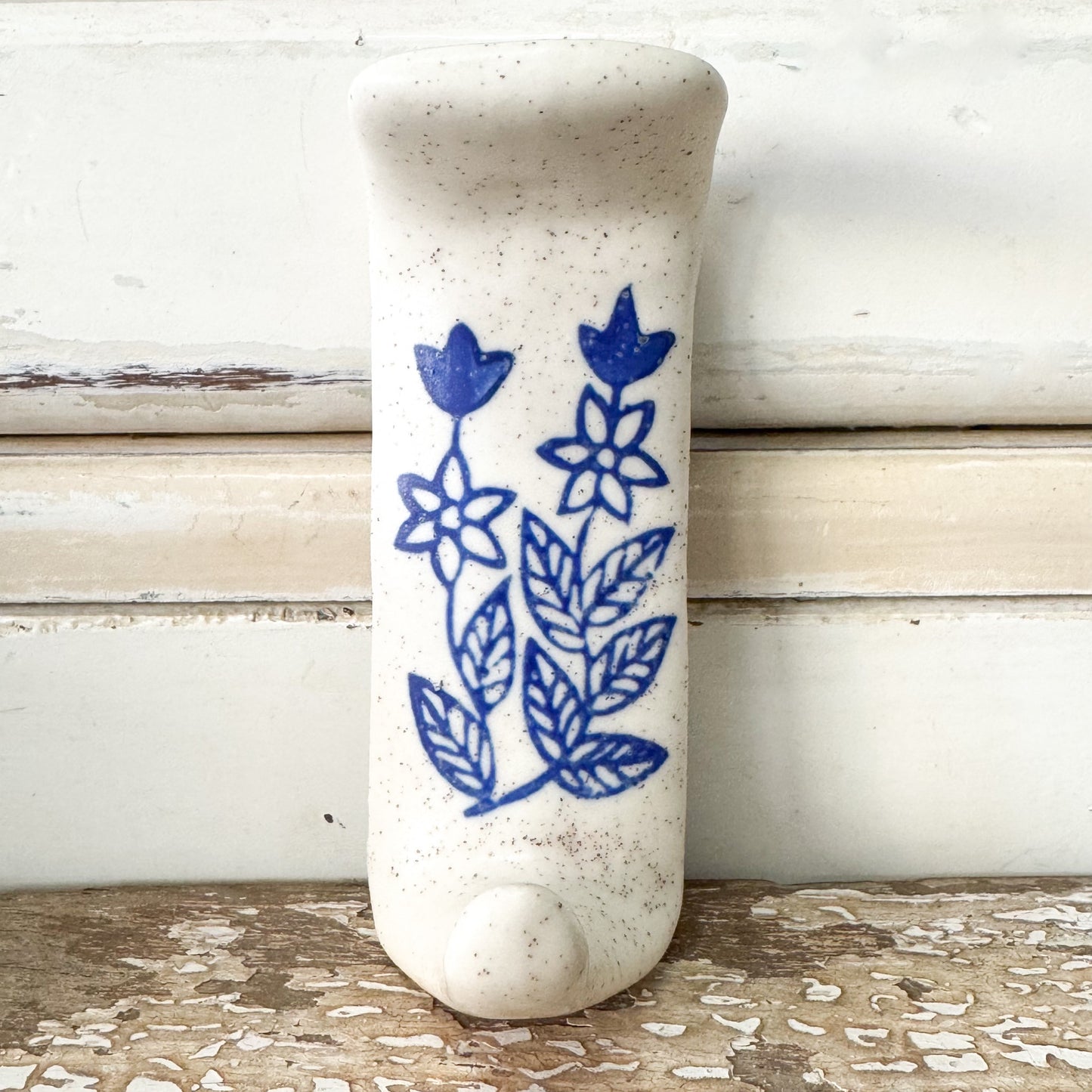 White ceramic hook with blue floral design 