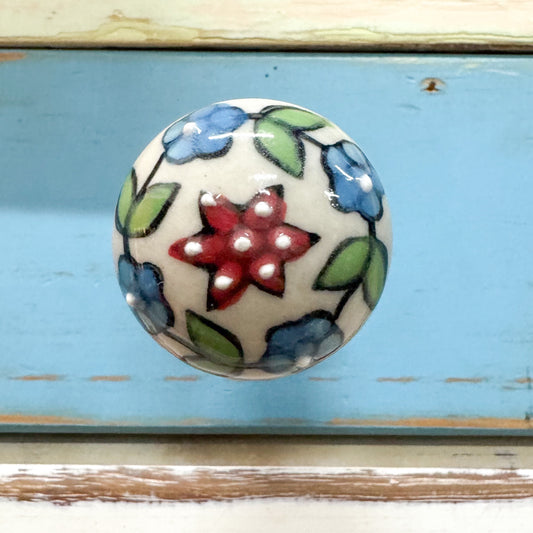 Decorative ceramic knob hook with floral design screws directly into the wall.