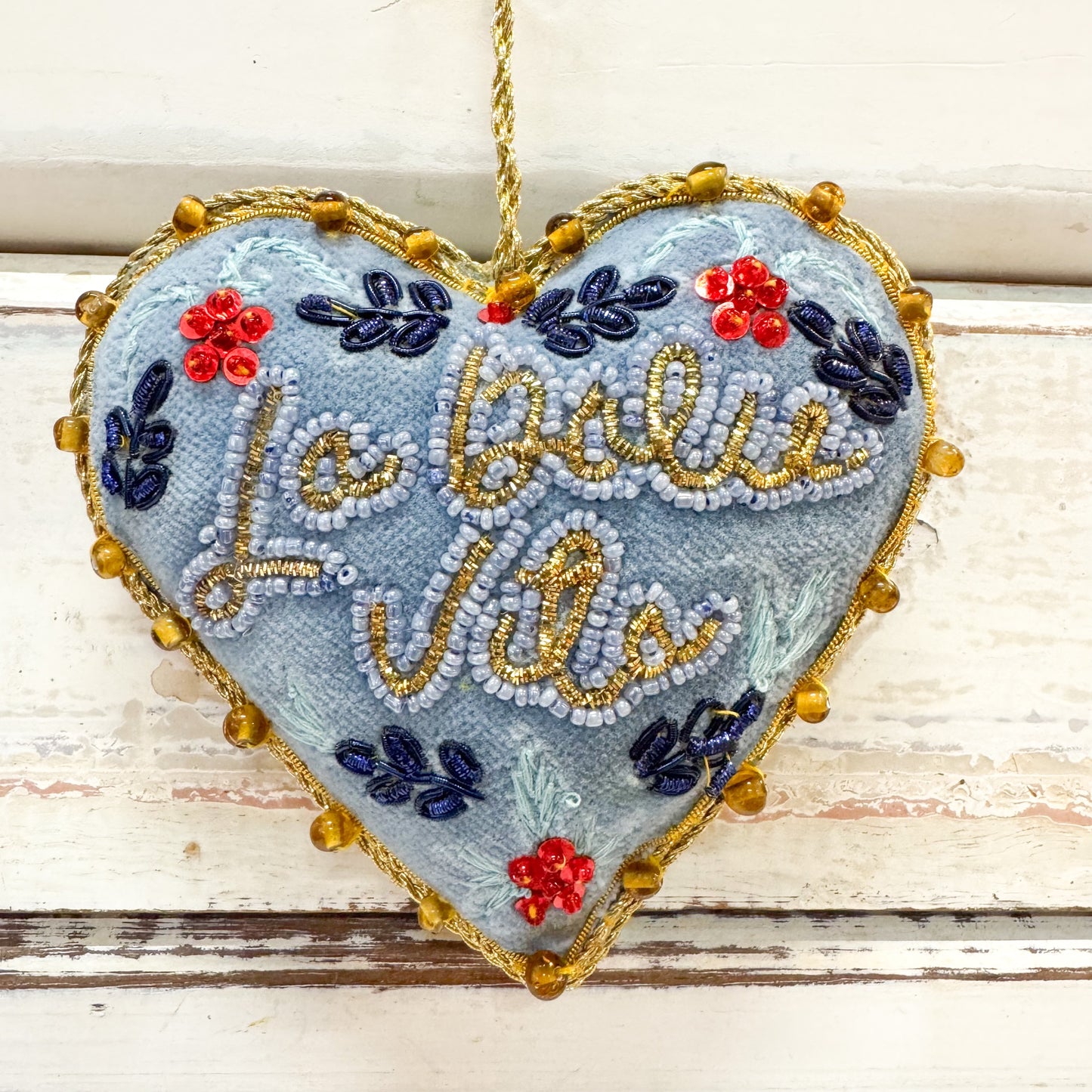 Heart-shaped embroidered decoration with floral designs and 'La Dolce Vita' text 