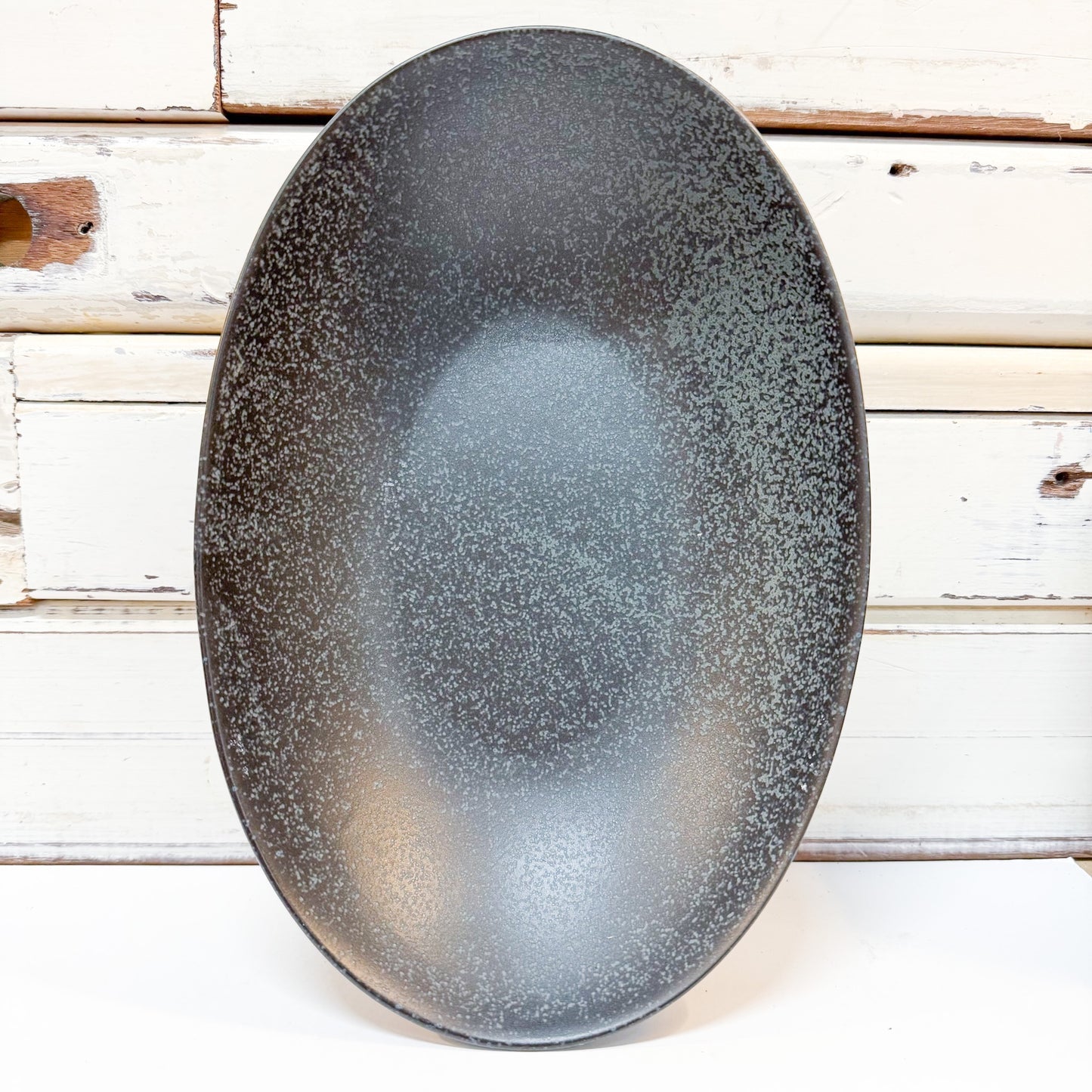 Concept Japan - Wabisabi Black Long Oval Bowl. Speckled black ceramic bowl on a wooden surface