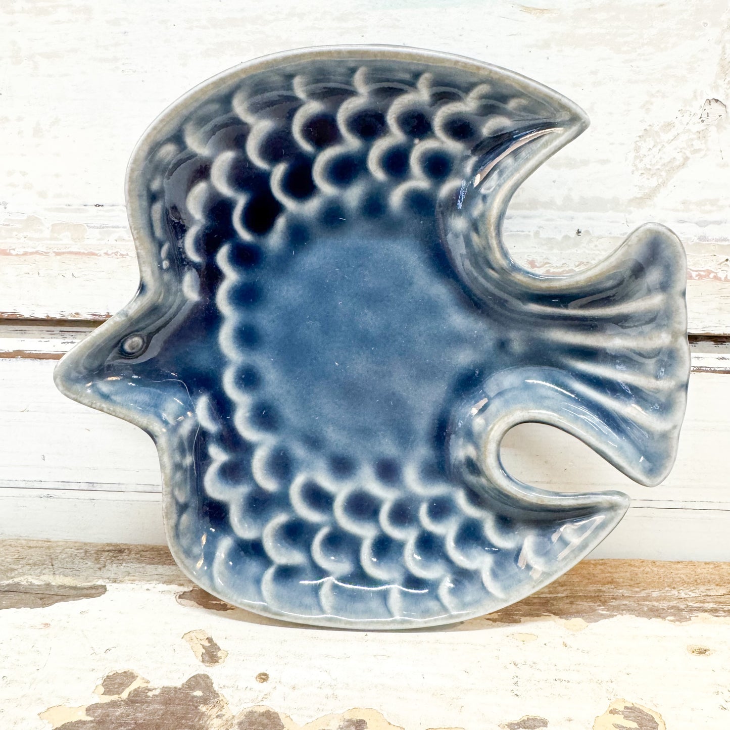 Concept Japan | Swallow Dish - Navy A ceramic bird-shaped dish with a blue and white scalloped pattern, set against a rustic white wooden background.