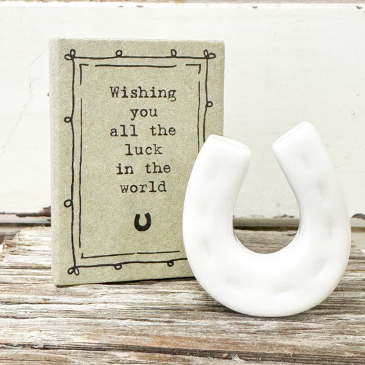 White ceramic horseshoe with a matchbox reading 'Wishing you all the luck in the world' 