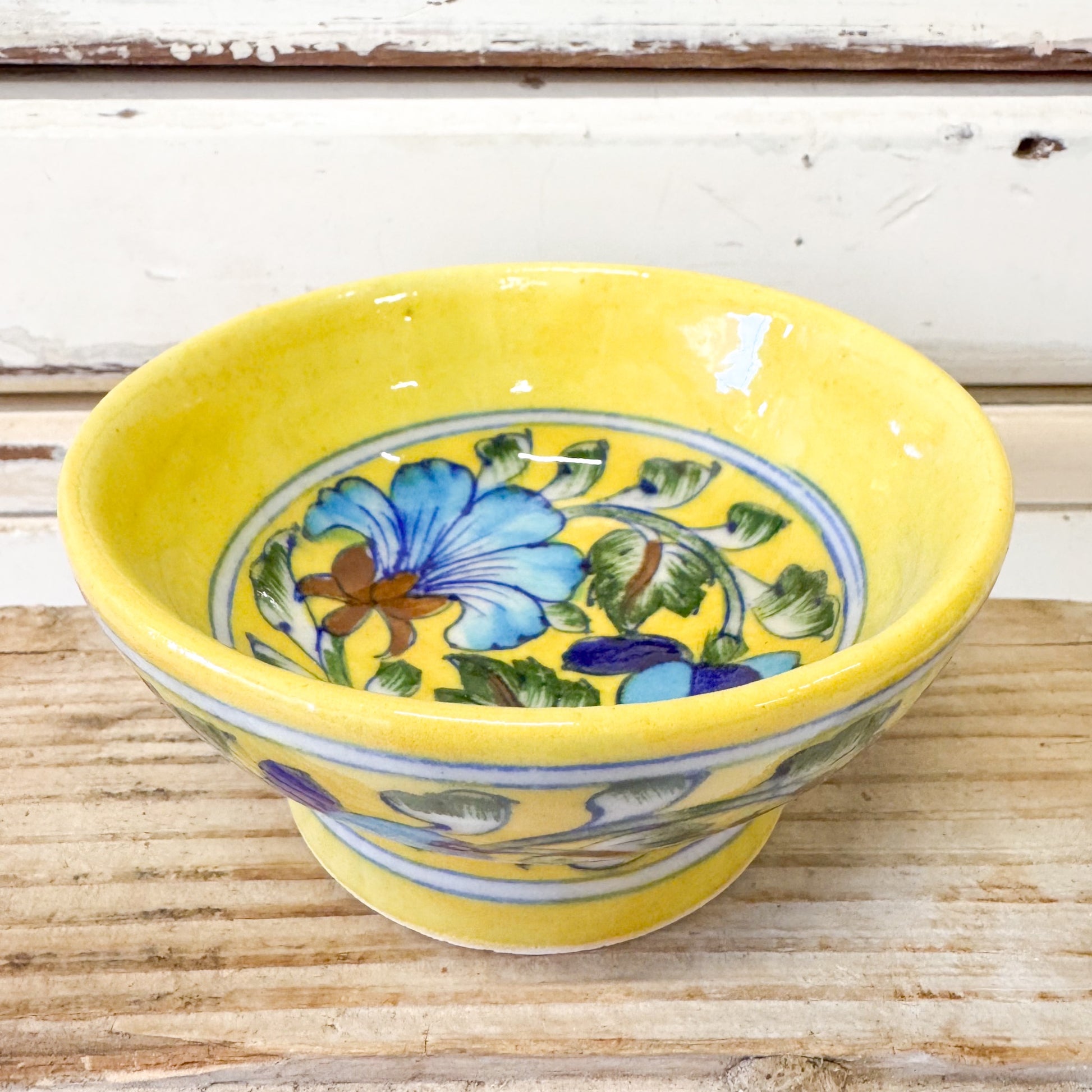 Indian Ceramics - Jaipur Yellow Tapas Bowl. Yellow ceramic bowl with floral design on a wooden surface