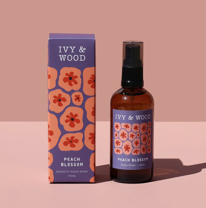 IVY & WOOD peach blossom room spray and packaging on a pink background