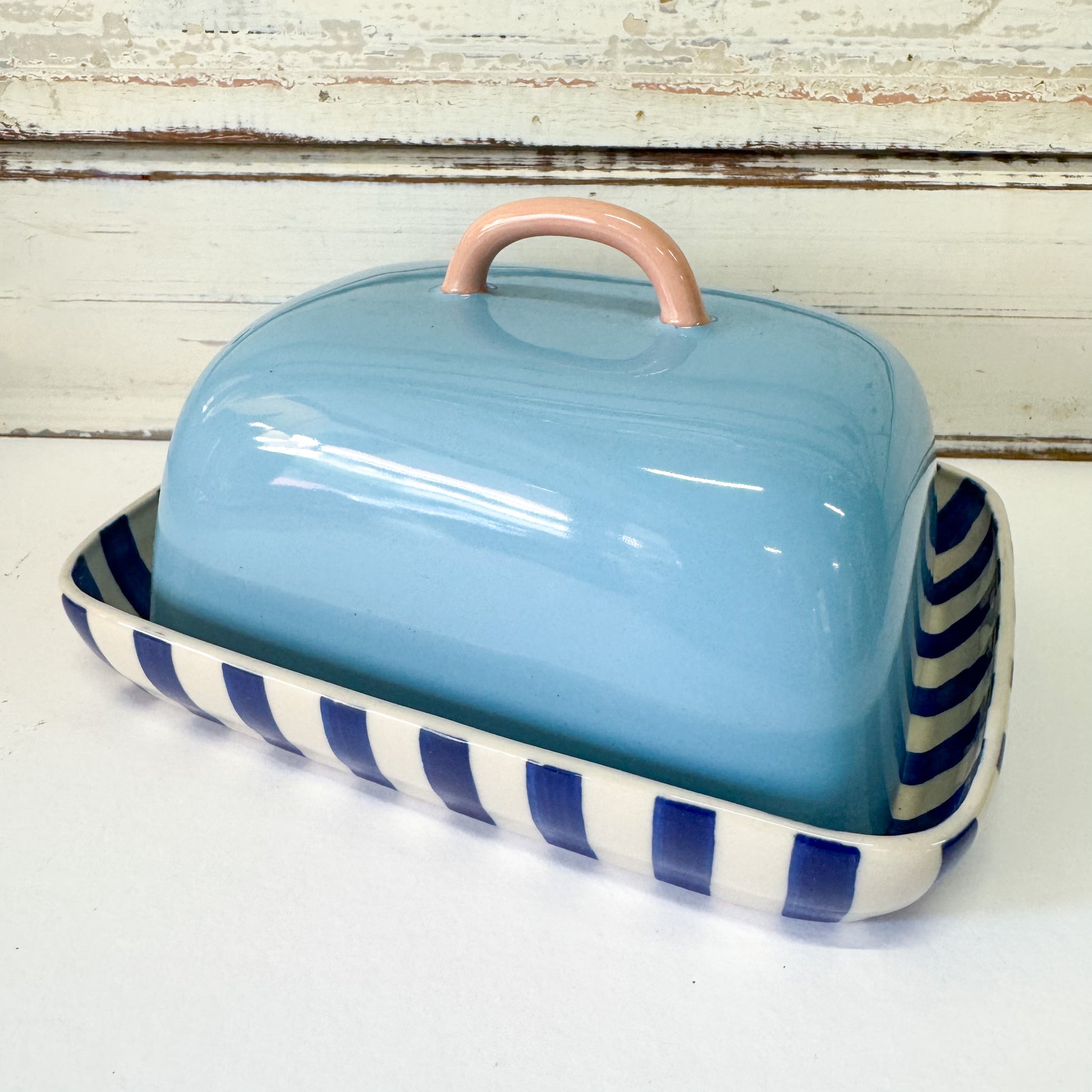 Blue ceramic butter dish with a striped base on a white surface. Jones & Co - Bloomie Butter Dish