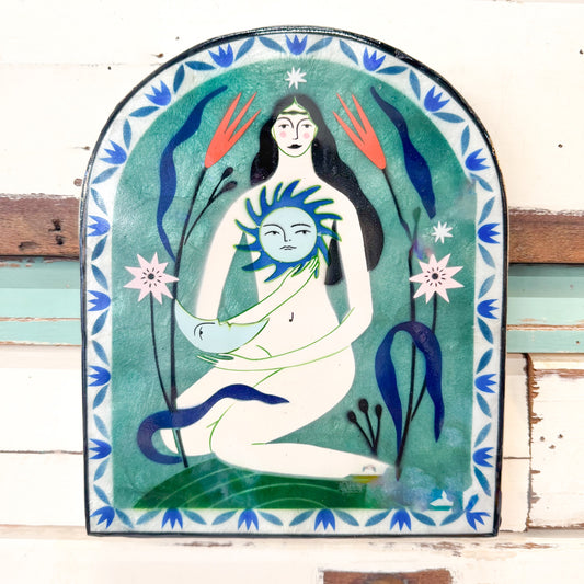 Decorative wall art with a stylized depiction of a woman holding a sun, surrounded by plants. Jones & Co - Fable Goddess Blue Arch