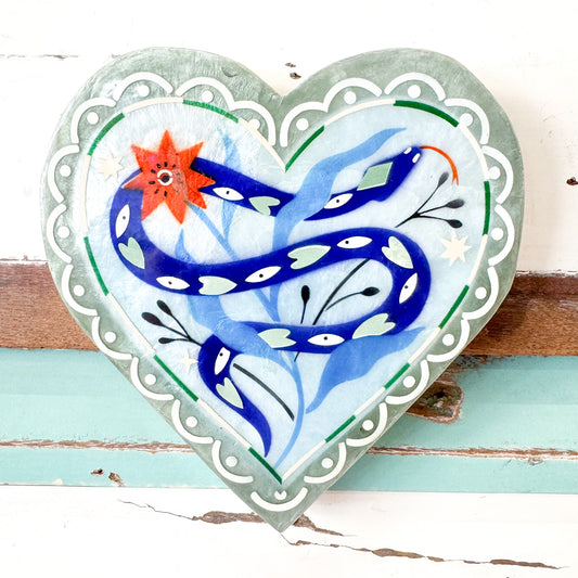Jones & Co - Fable Snake Blue Heart. Heart-shaped decorative item with blue snake design on a wooden surface