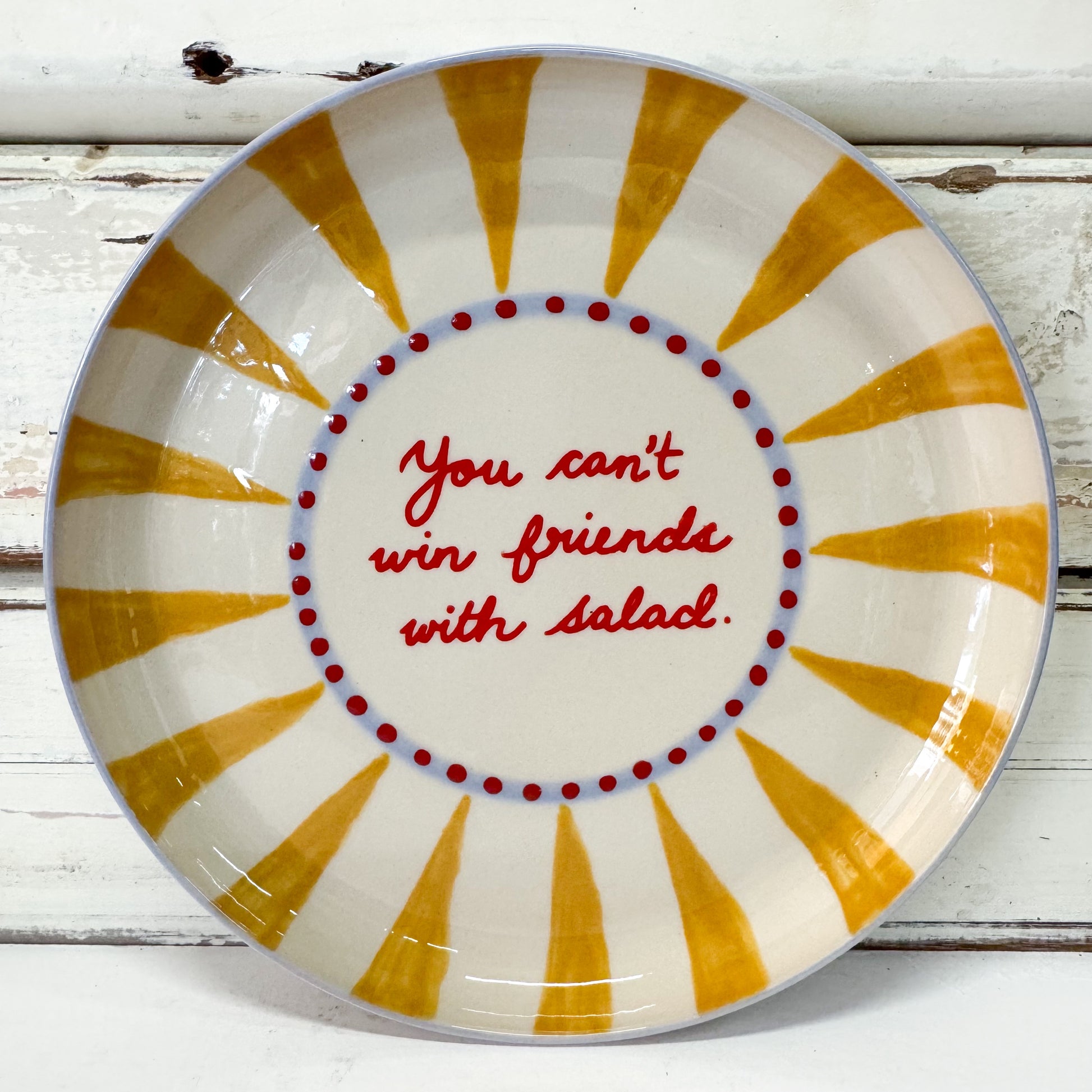 Decorative plate with yellow sunburst design and red text Jones & Co - Love Notes Plate - Win Friends