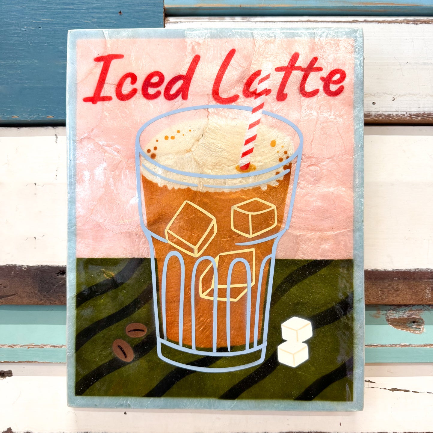 Illustration of an iced latte with ice cubes and a straw on a colourful background.
