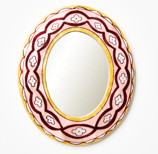 Decorative mirror with a pink and gold frame on a white background