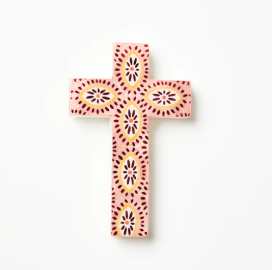 Decorative cross with pink and yellow patterns on a white background
