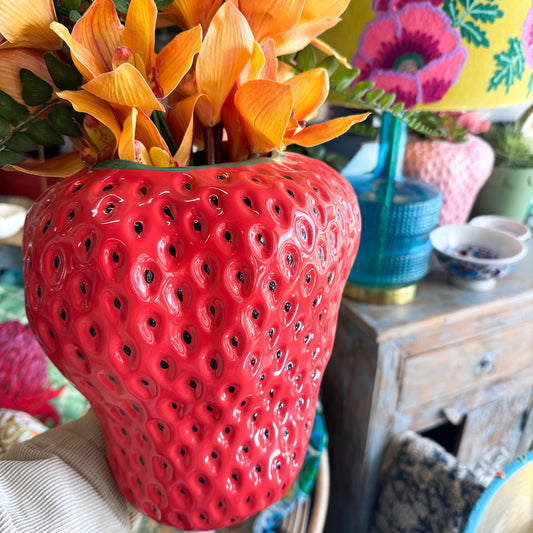 Kip&Co Strawberry Vase - Red strawberry-shaped vase with black pips & filled with green leaves and orange fruits.