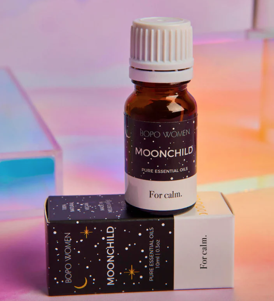 Bottle and box of 'Moonchild' pure essential oils by BOHO WOMEN on a colorful background