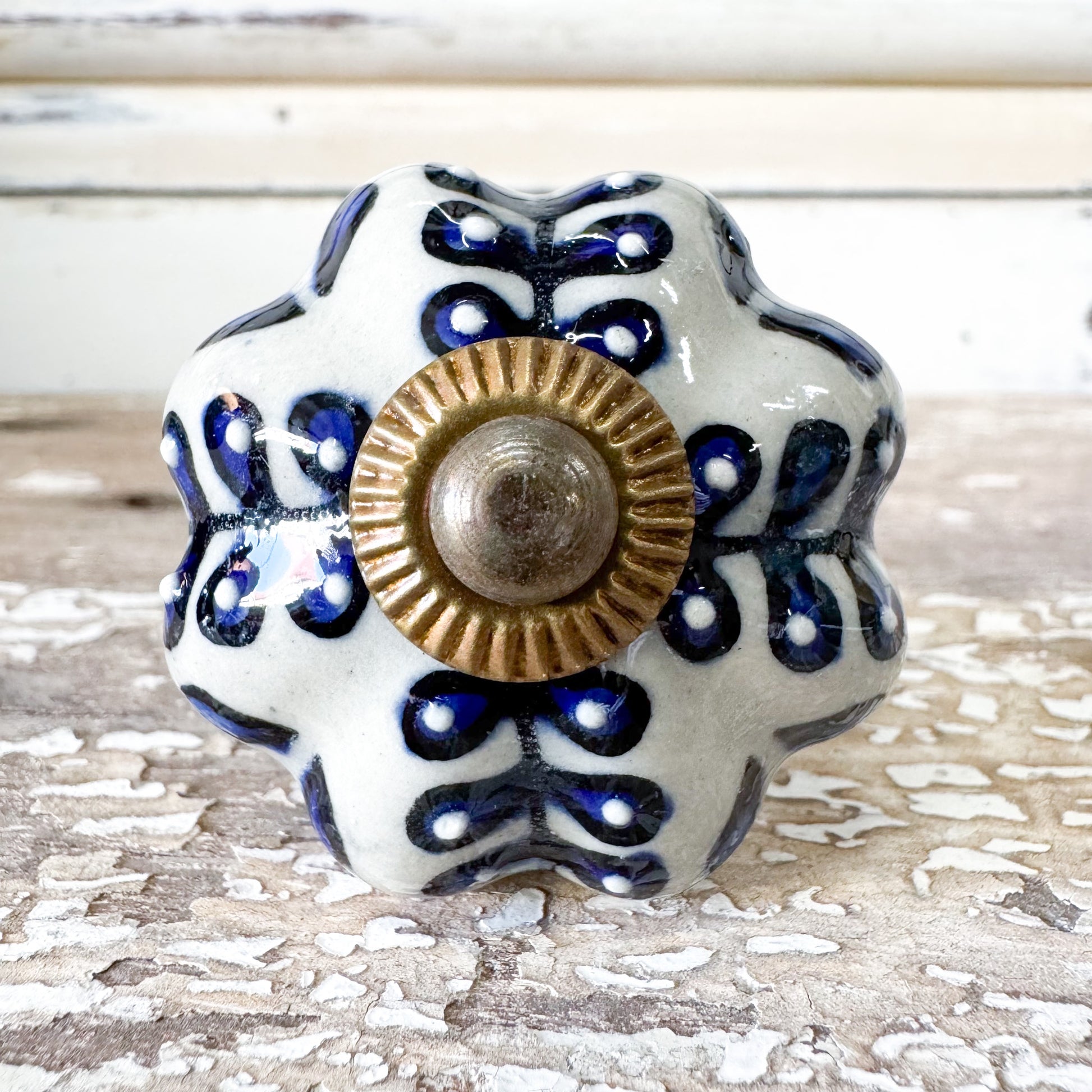 Decorative ceramic knob with blue patterns and a gold center 