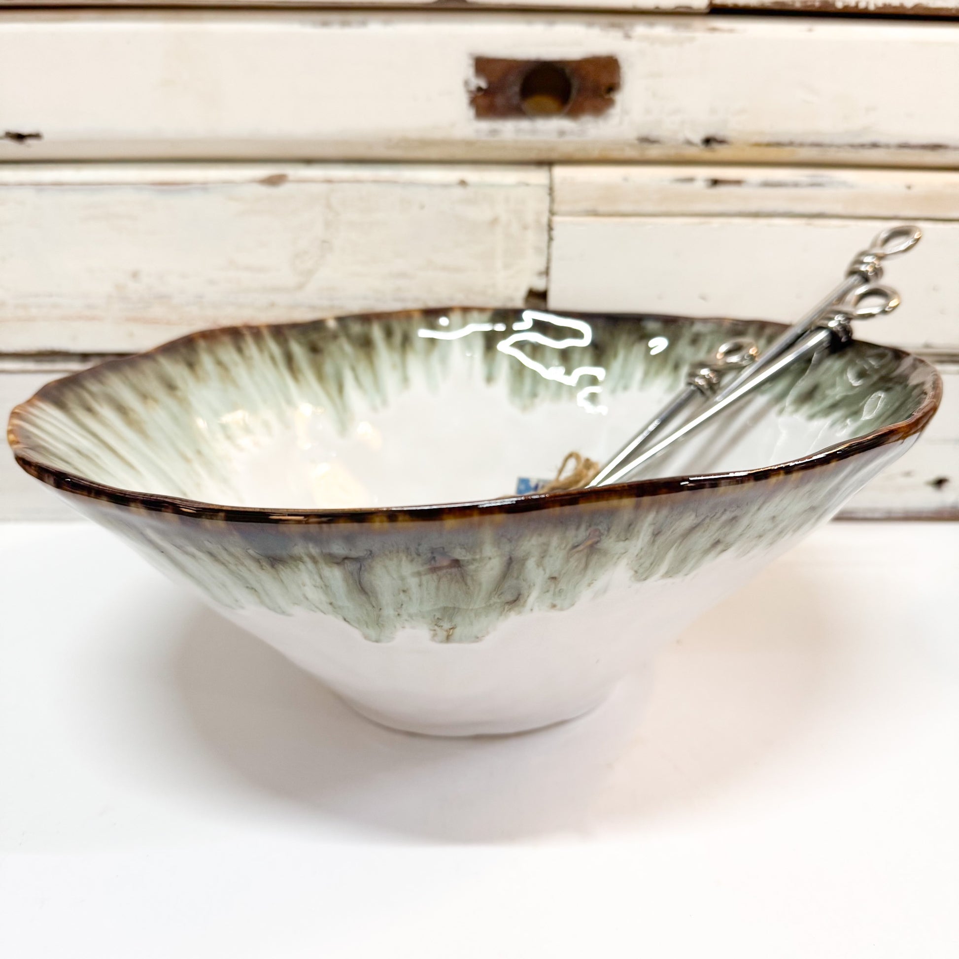 Ceramic bowl with decorative interior and spoon on a wooden surface