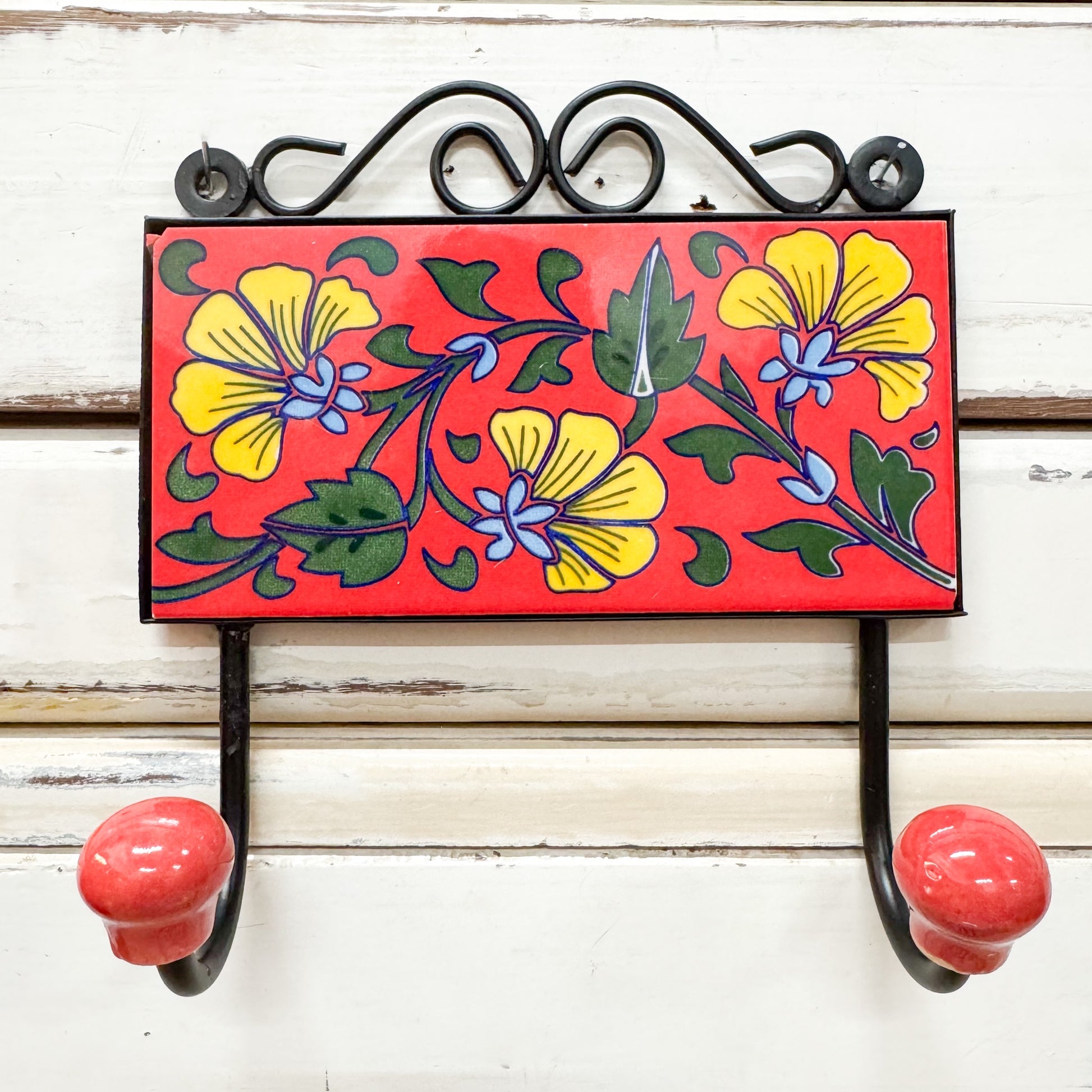 Decorative tile wall hook with floral design and red background