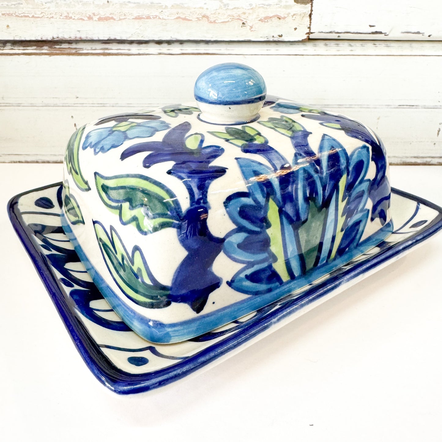 Status Collections - Leafy Blue Butter Dish. Ceramic butter dish with floral design on a white surface