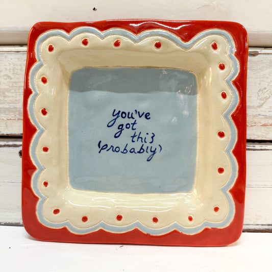 The Brightside Store | Lingo Tray - You Got This A square ceramic dish with a red outer border, cream scalloped inner border, and a light blue center featuring the handwritten phrase 'you've got this probably' in dark blue ink.