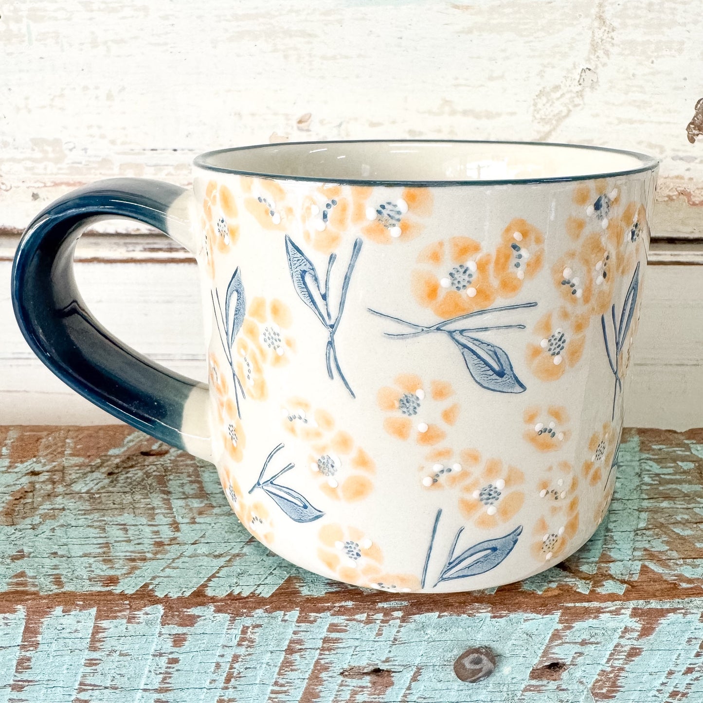 Ceramic mug with floral pattern on a rustic wooden surface