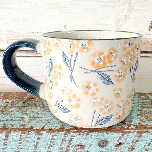 Ceramic mug with floral pattern on a rustic wooden surface