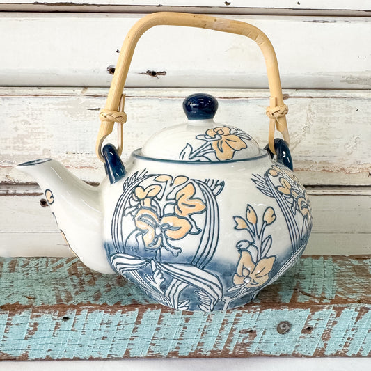 Decorative teapot with floral patterns on a rustic wooden surface