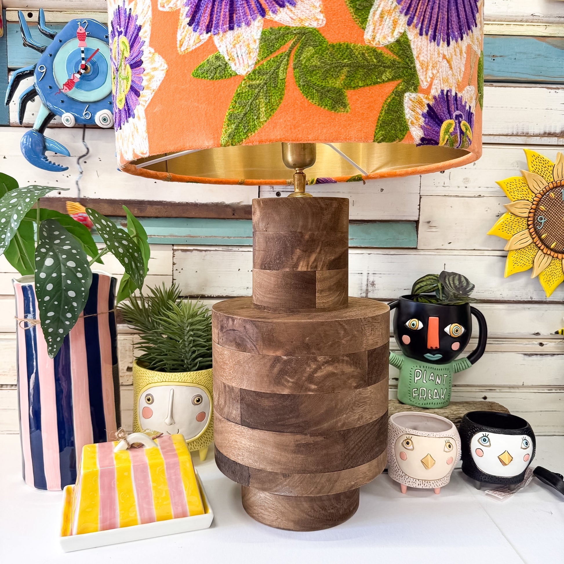Decorative items including a wooden lamp, colorful lampshade, and various small objects on a white surface.