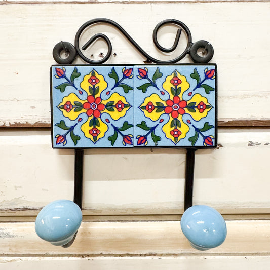 Decorative wall hook with colorful tile design and blue knobs 