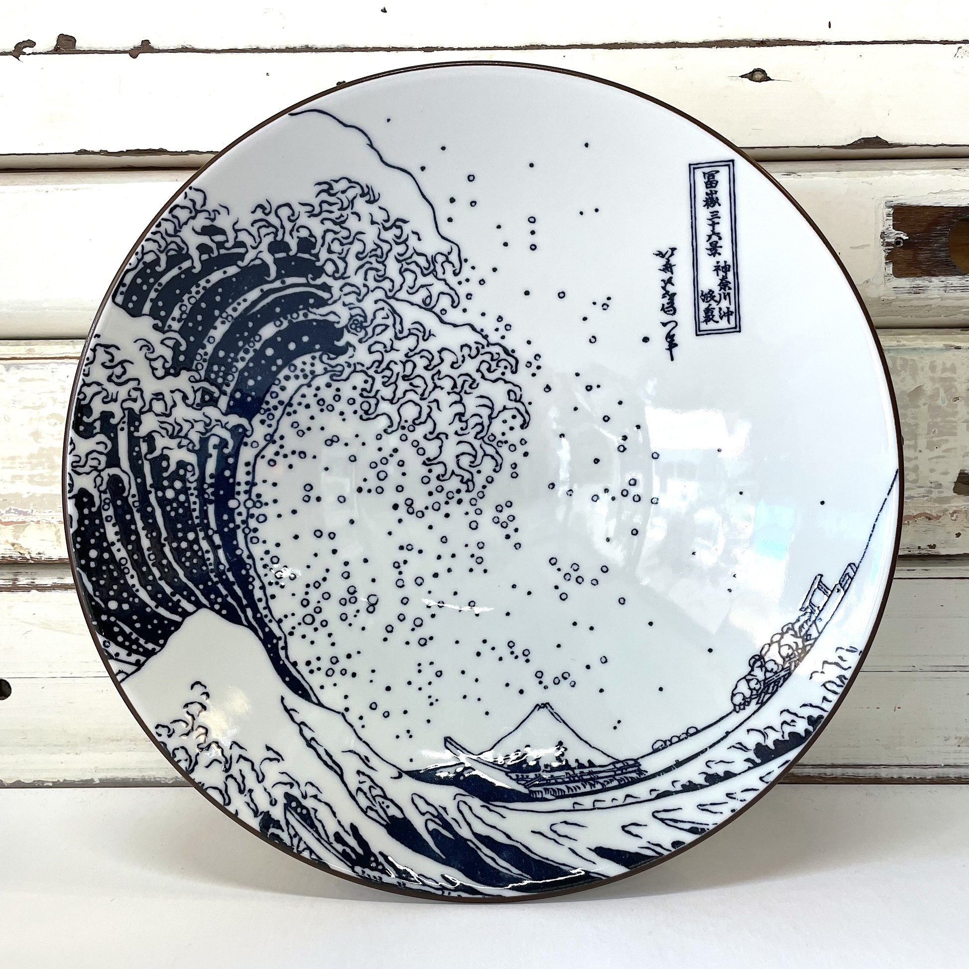 A large ceramic bowl with a white background featuring a blue and black wave pattern, inspired by Katsushika Hokusai's Great Wave painting. Concept Japan - Hokusai Fuji Large Bowl