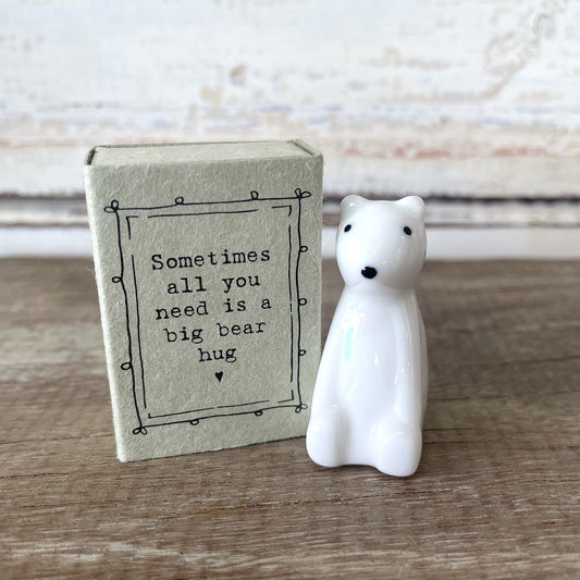 A white porcelain bear figurine next to its packaging box with the text 'Sometimes all you need is a big bear hug' on it.