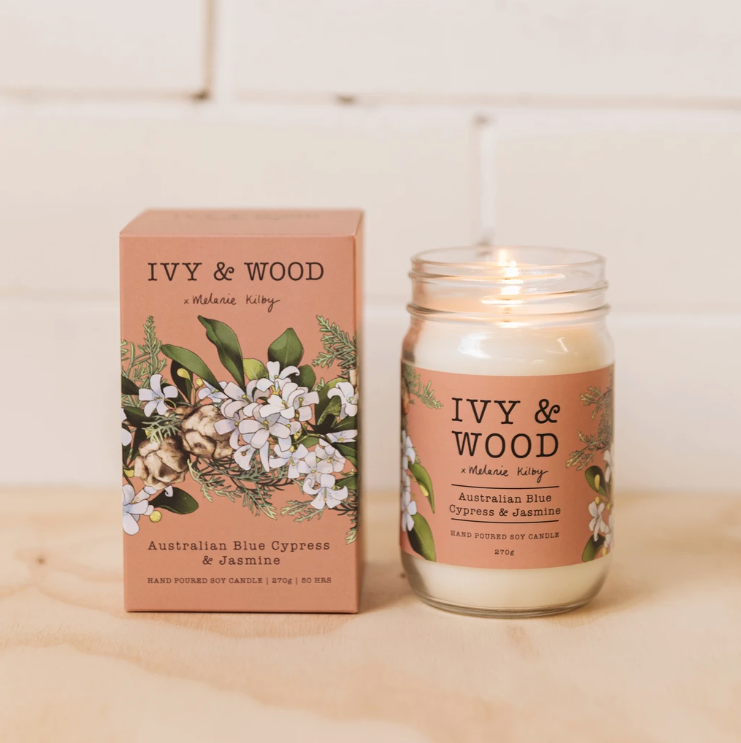 Australian Blue Cypress & Jasmine candle by Ivy & Wood, shown in a clear glass jar with a beige label, next to its packaging box adorned with floral illustrations. The Brightside Store