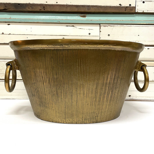 RUBY STAR TRADERS Champagne Bucket A gold-colored, cylindrical aluminum champagne bucket with a textured surface and two handles on the sides.